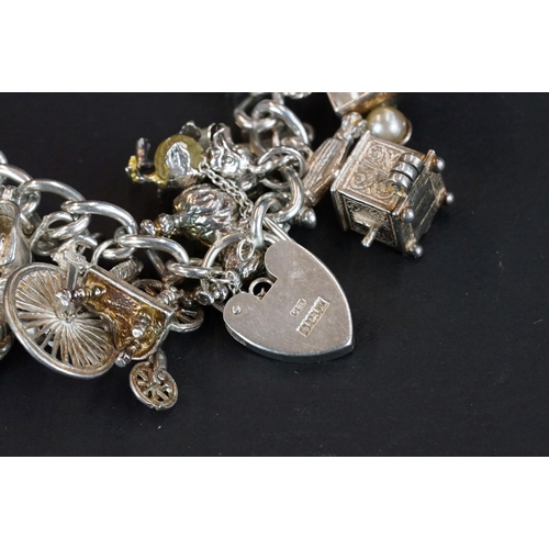 238 - A hallmarked sterling silver charm bracelet complete with a good quantity of charms together with a ... 