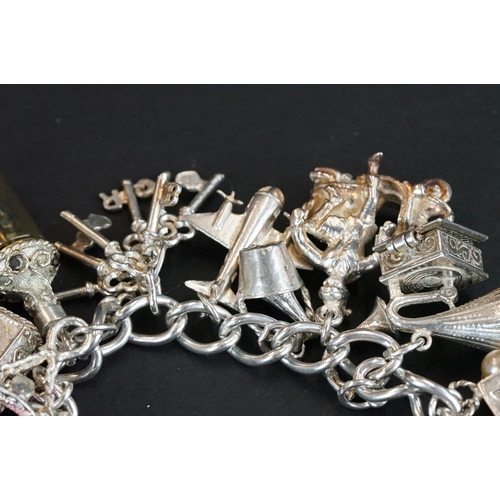 238 - A hallmarked sterling silver charm bracelet complete with a good quantity of charms together with a ... 