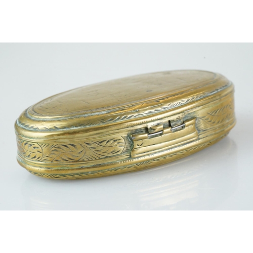 374 - An antique 18th century oval brass snuff box with ornate chased decoration.