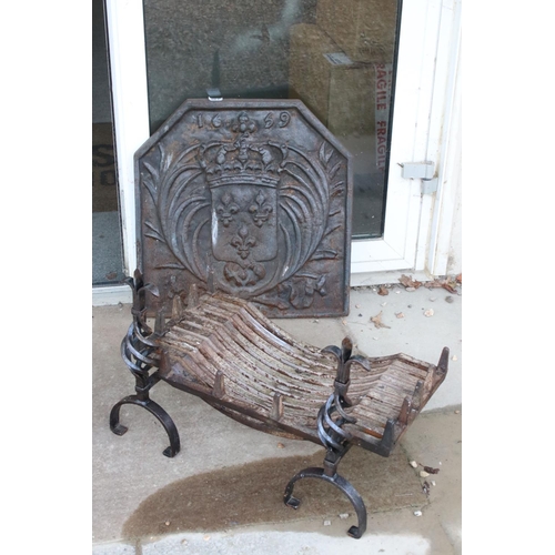 561 - A large antique cast iron fire back together with grill and fire dogs.