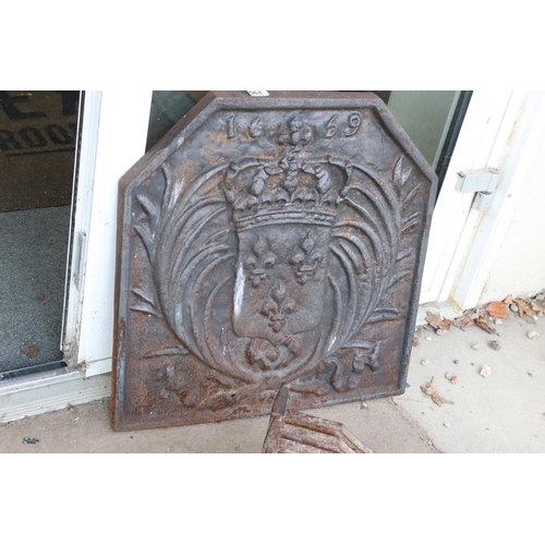 561 - A large antique cast iron fire back together with grill and fire dogs.