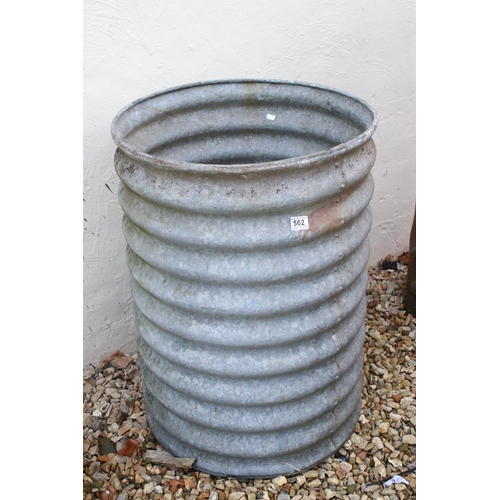 562 - A galvanised ribbed water tank or butt of riveted construction, with tap, h: 79cm, diameter 56cm