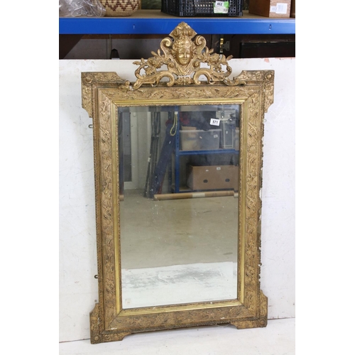 571 - 19th century Gilt Framed Mirror, the scrolling crest holding a face mask and with moulded floral det... 