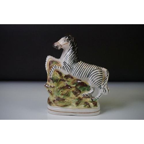 64 - Pair of Staffordshire rearing zebra porcelain figures on a naturalistic ground, 16cm high, together ... 