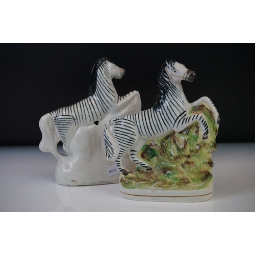 64 - Pair of Staffordshire rearing zebra porcelain figures on a naturalistic ground, 16cm high, together ... 