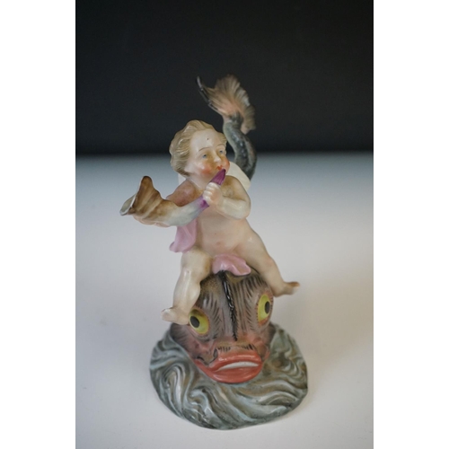 67 - A Continental porcelain figure of a cherub on a dolphin, h: 11.5cm