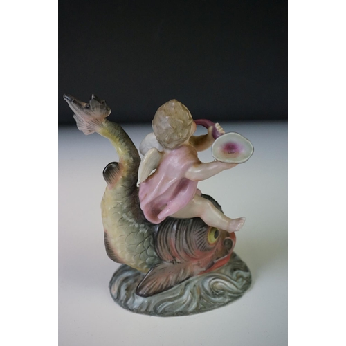 67 - A Continental porcelain figure of a cherub on a dolphin, h: 11.5cm