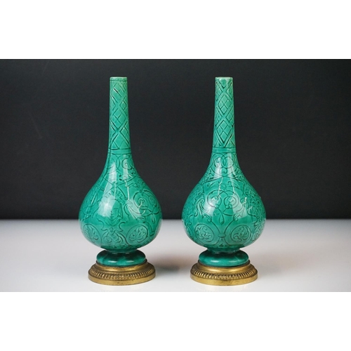 7 - Pair of Chinese green glazed bud vases of baluster form, decorated with faces and foliate decoration... 