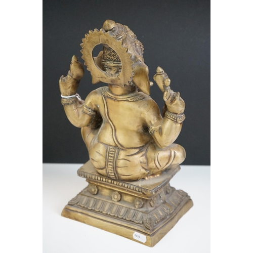 106 - Heavy Cast Brass Indian figure of Hindu Deity Ganesh, sat on a raised square plinth, holding objects... 