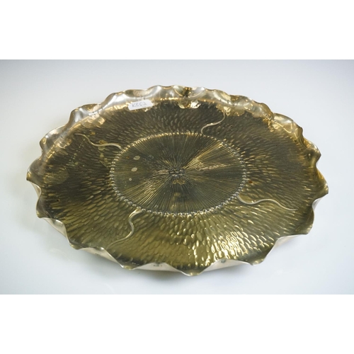 109 - An unusual Aesthetic period plated tray of shaped circular outline of lily pad design and hammered d... 