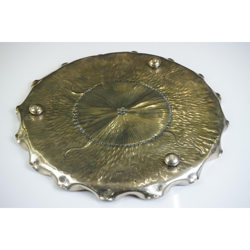 109 - An unusual Aesthetic period plated tray of shaped circular outline of lily pad design and hammered d... 