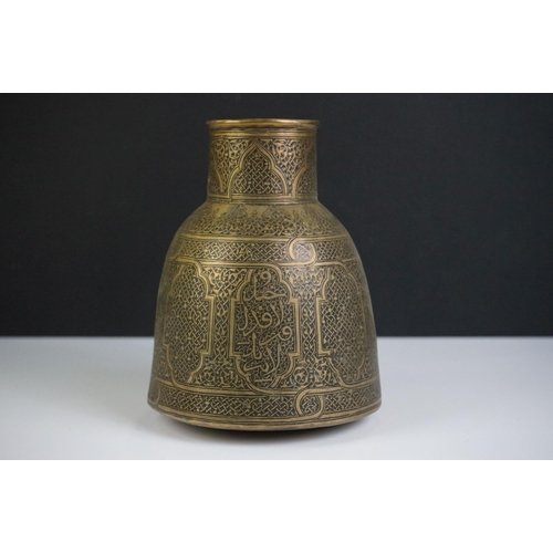 111 - Islamic brass jug of tapering form, heavily decorated with chased decoration, 15cm high