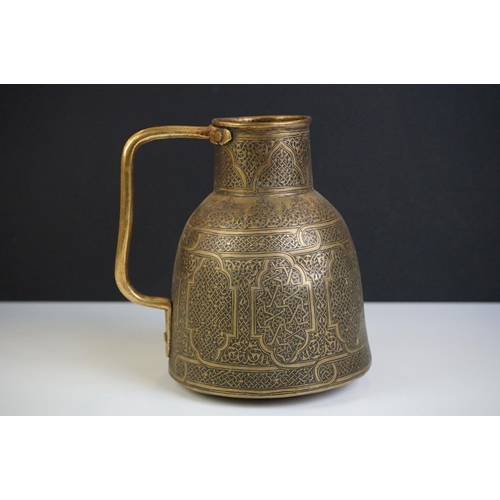 111 - Islamic brass jug of tapering form, heavily decorated with chased decoration, 15cm high