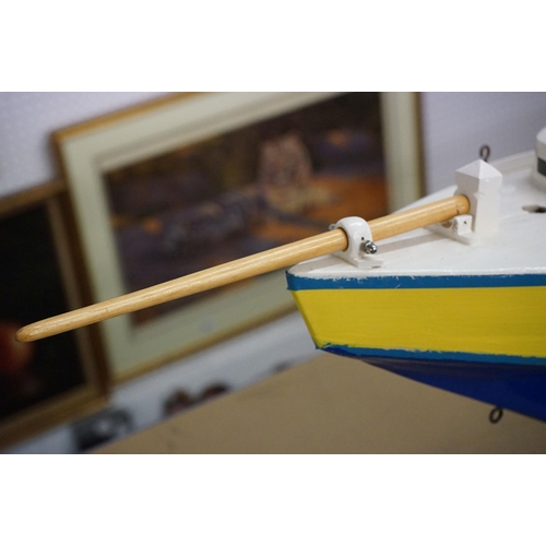 130 - Scratch-built painted wooden model of a yacht, in blue, yellow and white, with decking and hatch det... 