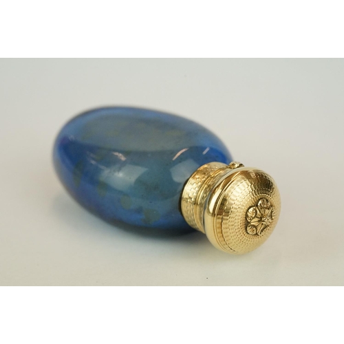 207 - Blue glass scent bottle, yellow metal lid with engine turned decoration, opening to reveal original ... 