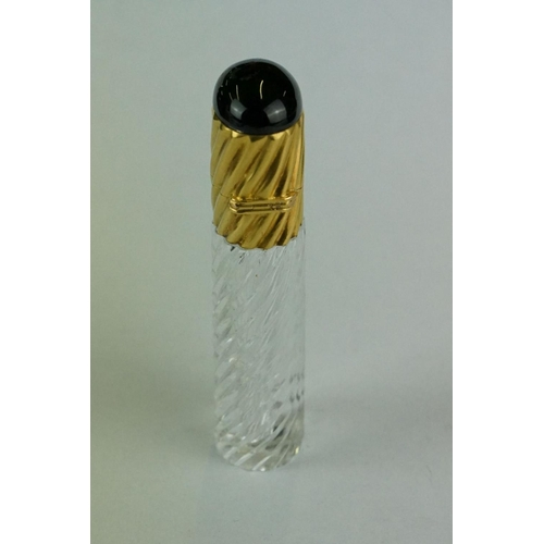 245 - 19th century cut glass garnet topped yellow metal scent bottle, writhen glass body, the writhen yell... 