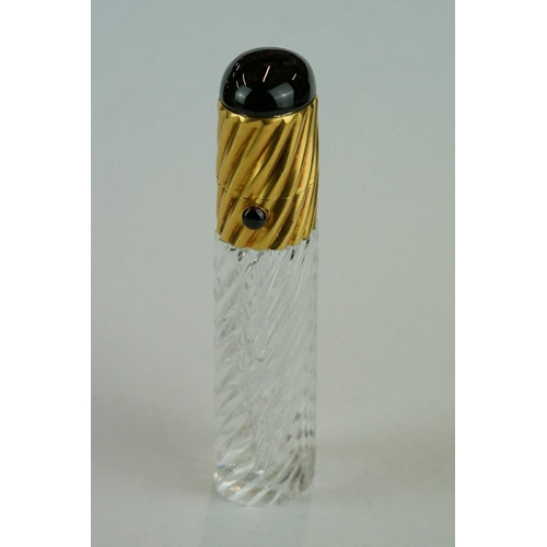 245 - 19th century cut glass garnet topped yellow metal scent bottle, writhen glass body, the writhen yell... 