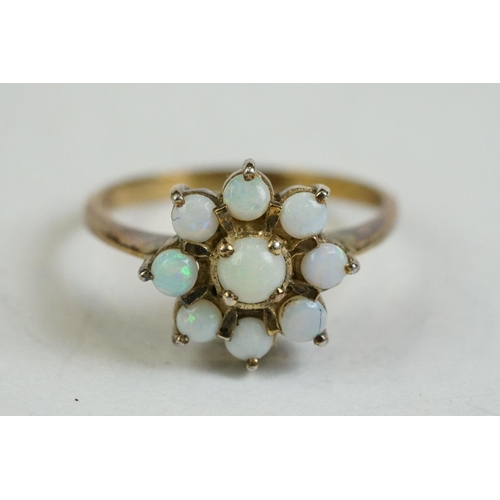 171 - A ladies yellow metal dress ring set with 9 cabochon opals.