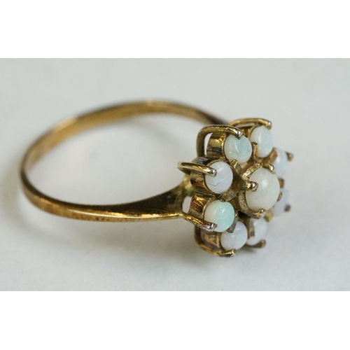 171 - A ladies yellow metal dress ring set with 9 cabochon opals.