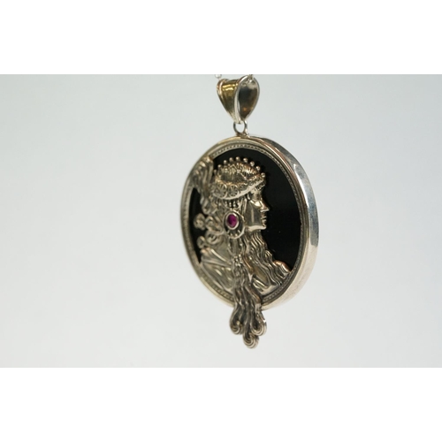 193 - A silver and onyx pendant necklace in the form of a lady with a cabouchon ruby