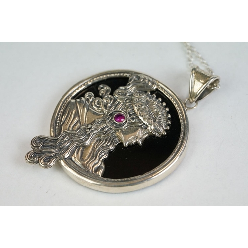 193 - A silver and onyx pendant necklace in the form of a lady with a cabouchon ruby