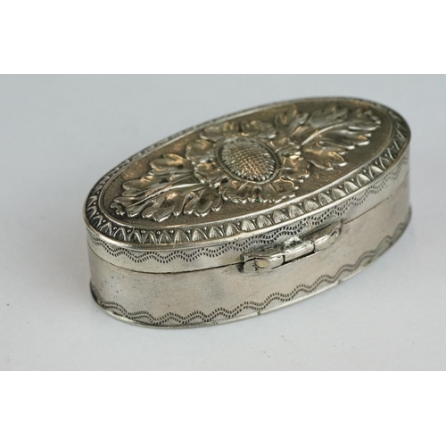 261 - White metal oval vinaigrette, the hinged lid with repousse floral decoration, the body with engraved... 