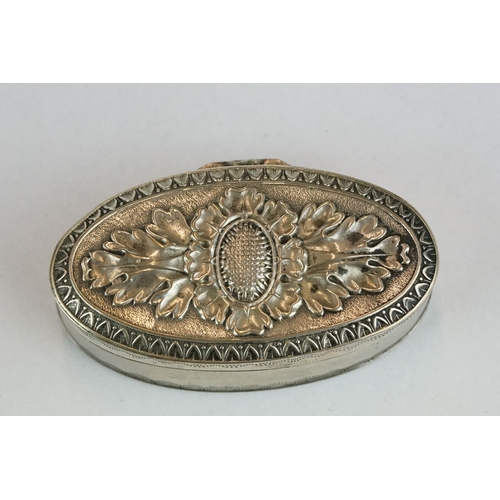 261 - White metal oval vinaigrette, the hinged lid with repousse floral decoration, the body with engraved... 