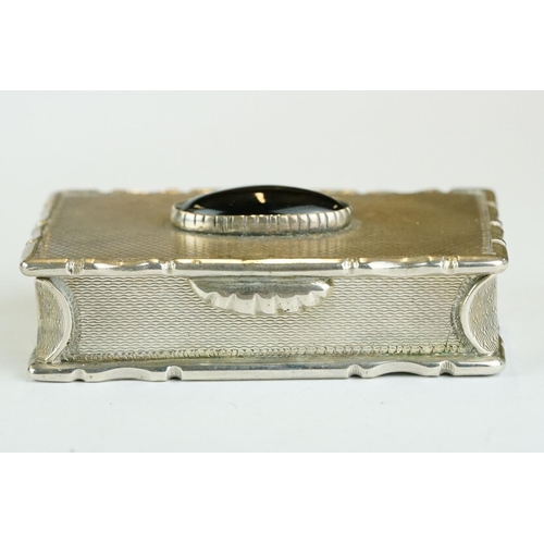 270 - George IV silver snuff box, the engine turned hinged lid set with black onyx oval cabochon, cast sty... 