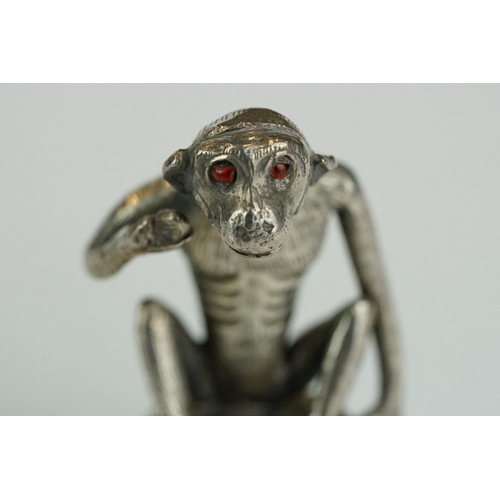 278 - Continental white metal figurine modelled as a squatting monkey, red glass eyes, height approx 3.5cm... 