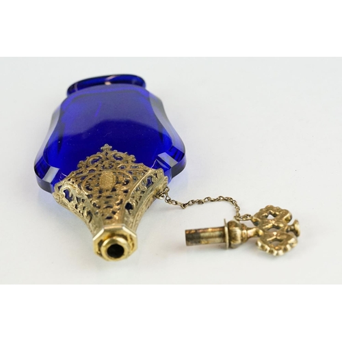 289 - 18th century blue glass gilt scent bottle, faceted hourglass body raised on foot, pierced gilt colla... 