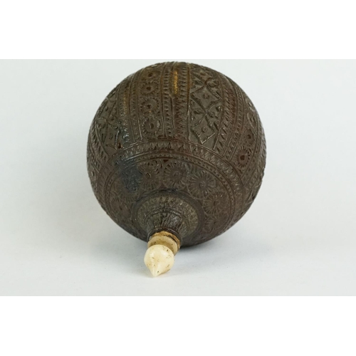 311 - Carved Persian nut scent bottle, bone ogee finial, the spherical body with carved floral and repeati... 