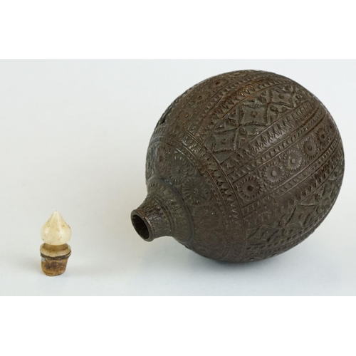 311 - Carved Persian nut scent bottle, bone ogee finial, the spherical body with carved floral and repeati... 