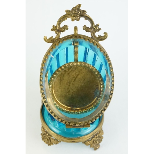 336 - Late 19th century blue glass and brass pocket watch display case, raised on four cast feet, rose bud... 