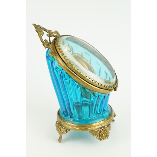 336 - Late 19th century blue glass and brass pocket watch display case, raised on four cast feet, rose bud... 