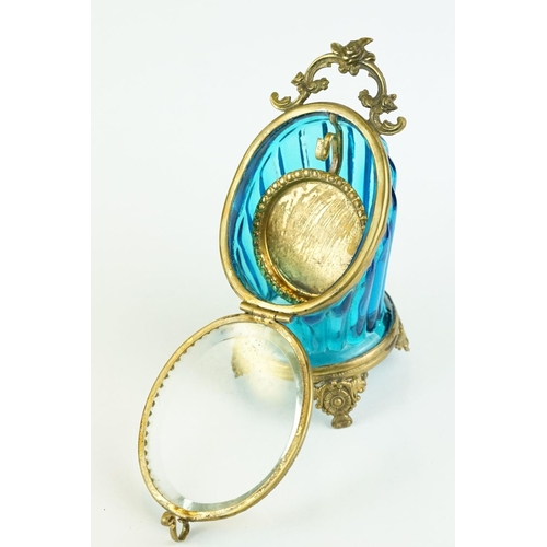 336 - Late 19th century blue glass and brass pocket watch display case, raised on four cast feet, rose bud... 