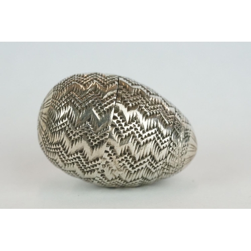 340 - Unmarked silver pomander, modelled as an egg with punched and engraved zig zag decoration, circa 170... 