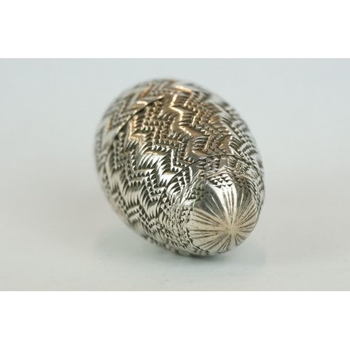 340 - Unmarked silver pomander, modelled as an egg with punched and engraved zig zag decoration, circa 170... 