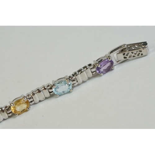 346 - A silver bracelet set with amethyst, peridot, ruby, aquamarine etc