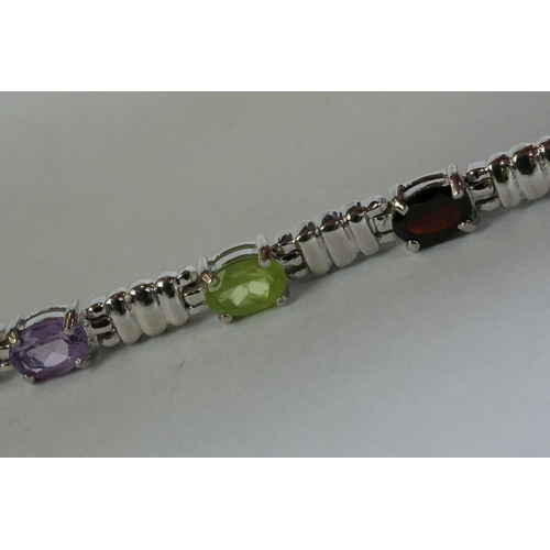 346 - A silver bracelet set with amethyst, peridot, ruby, aquamarine etc