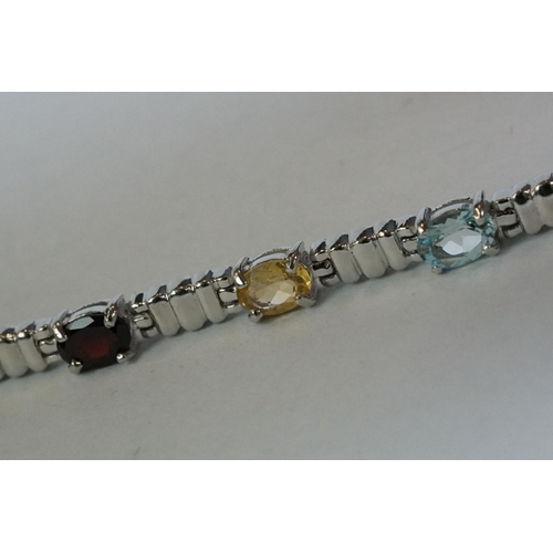 346 - A silver bracelet set with amethyst, peridot, ruby, aquamarine etc