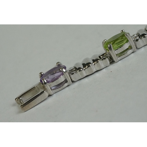 346 - A silver bracelet set with amethyst, peridot, ruby, aquamarine etc