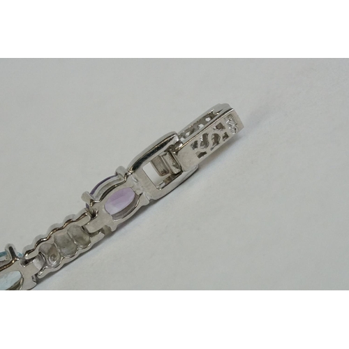 346 - A silver bracelet set with amethyst, peridot, ruby, aquamarine etc