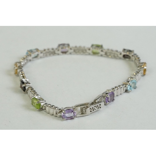 346 - A silver bracelet set with amethyst, peridot, ruby, aquamarine etc