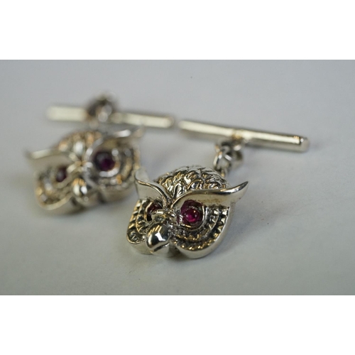 349 - A pair of silver owl head cufflinks with ruby eyes