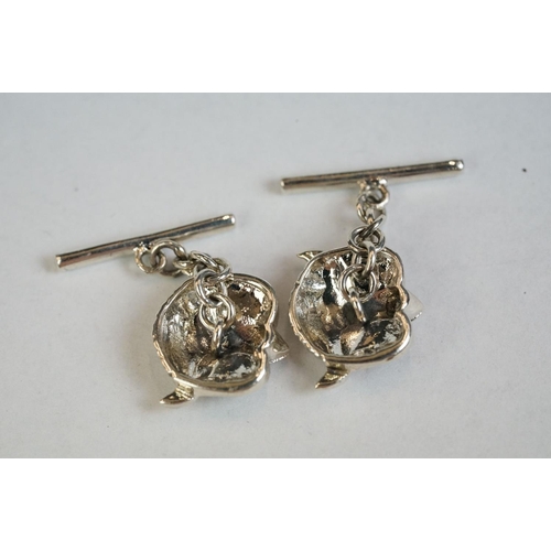 349 - A pair of silver owl head cufflinks with ruby eyes