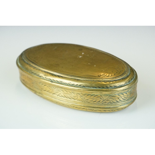 374 - An antique 18th century oval brass snuff box with ornate chased decoration.