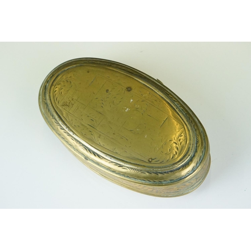 374 - An antique 18th century oval brass snuff box with ornate chased decoration.