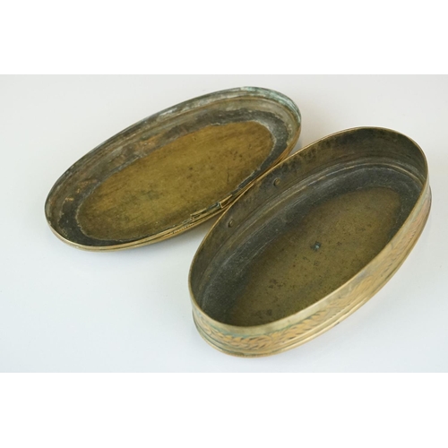 374 - An antique 18th century oval brass snuff box with ornate chased decoration.