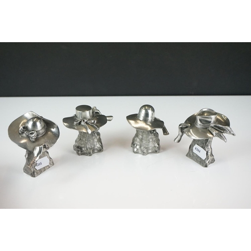 414 - A collection of four contemporary white metal hat ornaments, maker marked to verso.