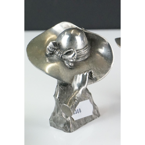 414 - A collection of four contemporary white metal hat ornaments, maker marked to verso.